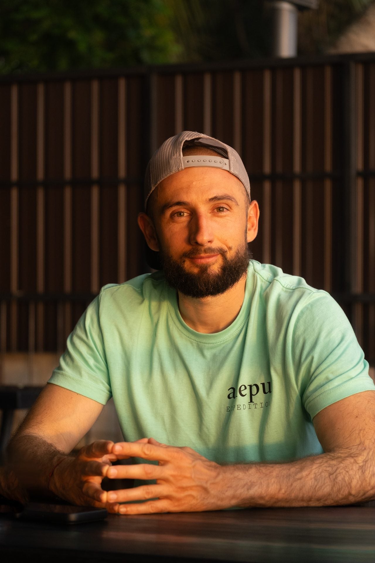 A member of the Alepu team sitting at a table in an Alepu Expedition shirt