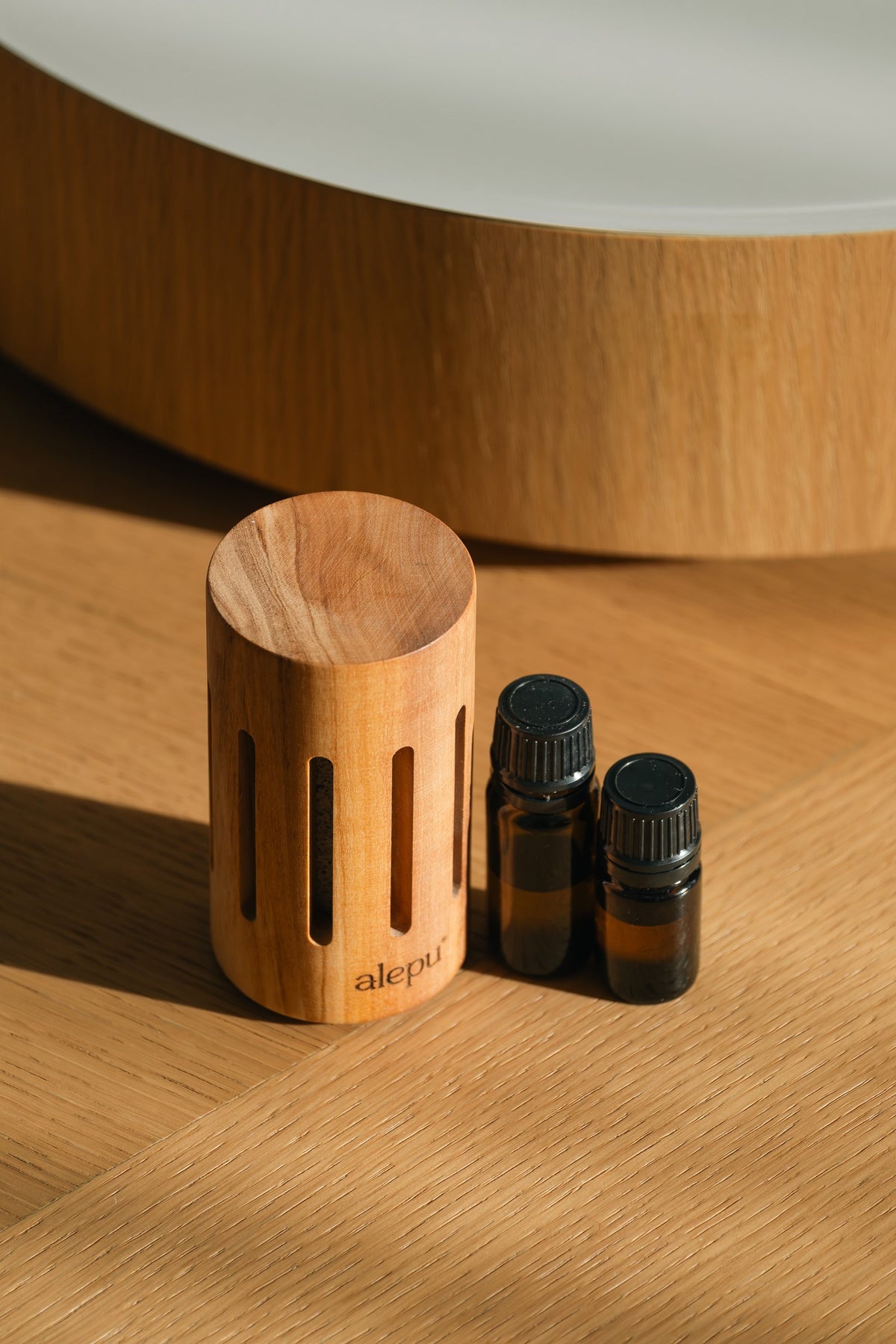 The round olive wood diffuser with two small oil bottles