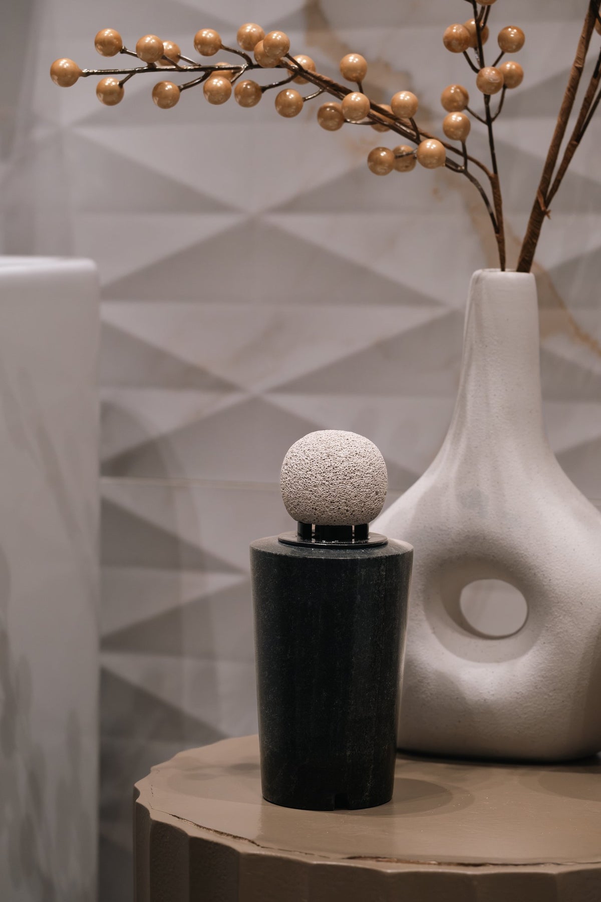 The dark marble diffuser with its round pumice stone
