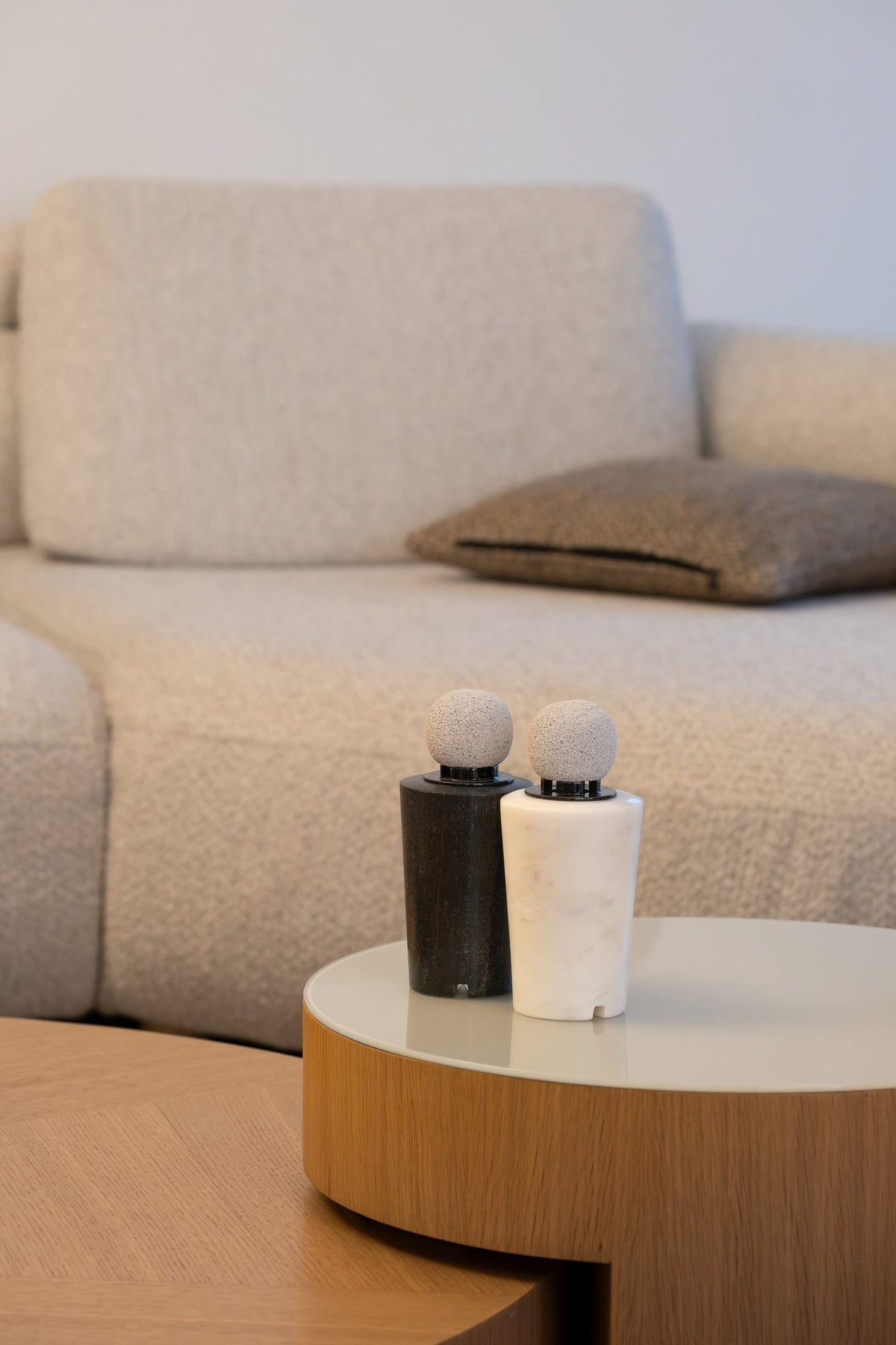 Dark and white marble diffusers on a side table by a sofa