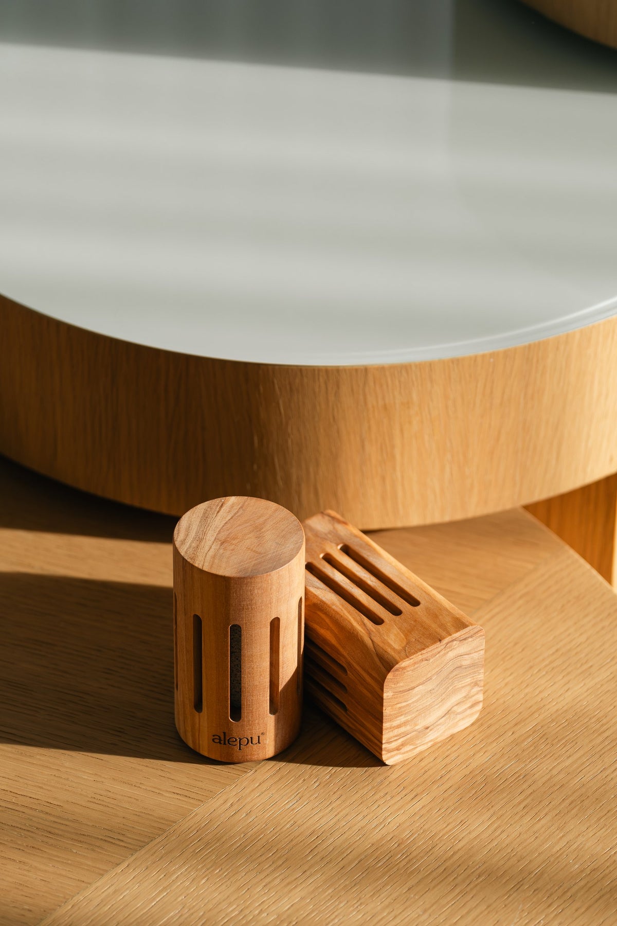 Square and round olive wood diffusers together in low sun