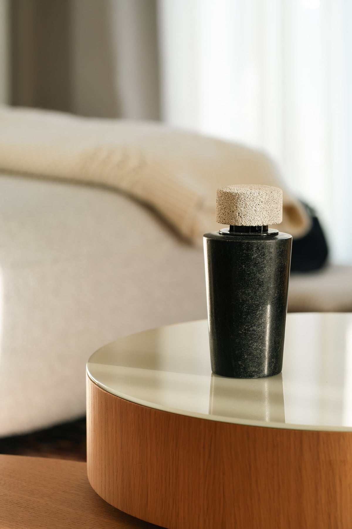 The dark marble diffuser on a glass-topped side table